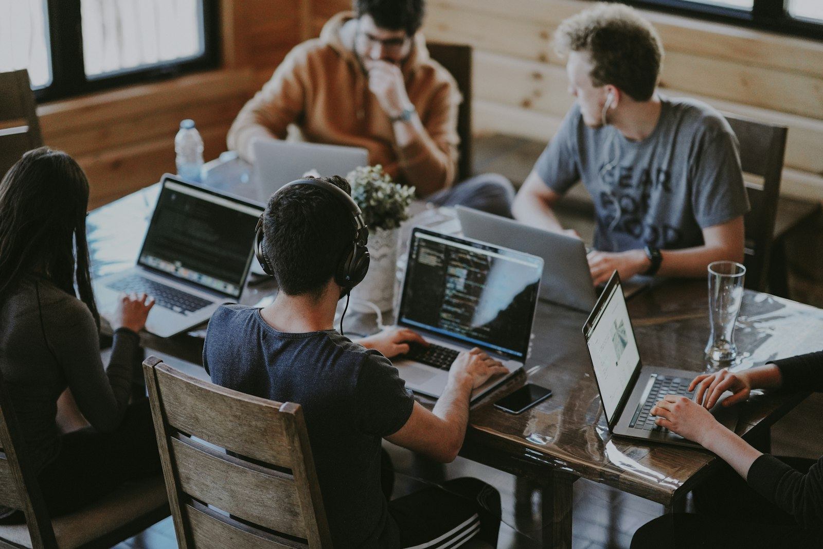 Employees working on laptops around a shared table.