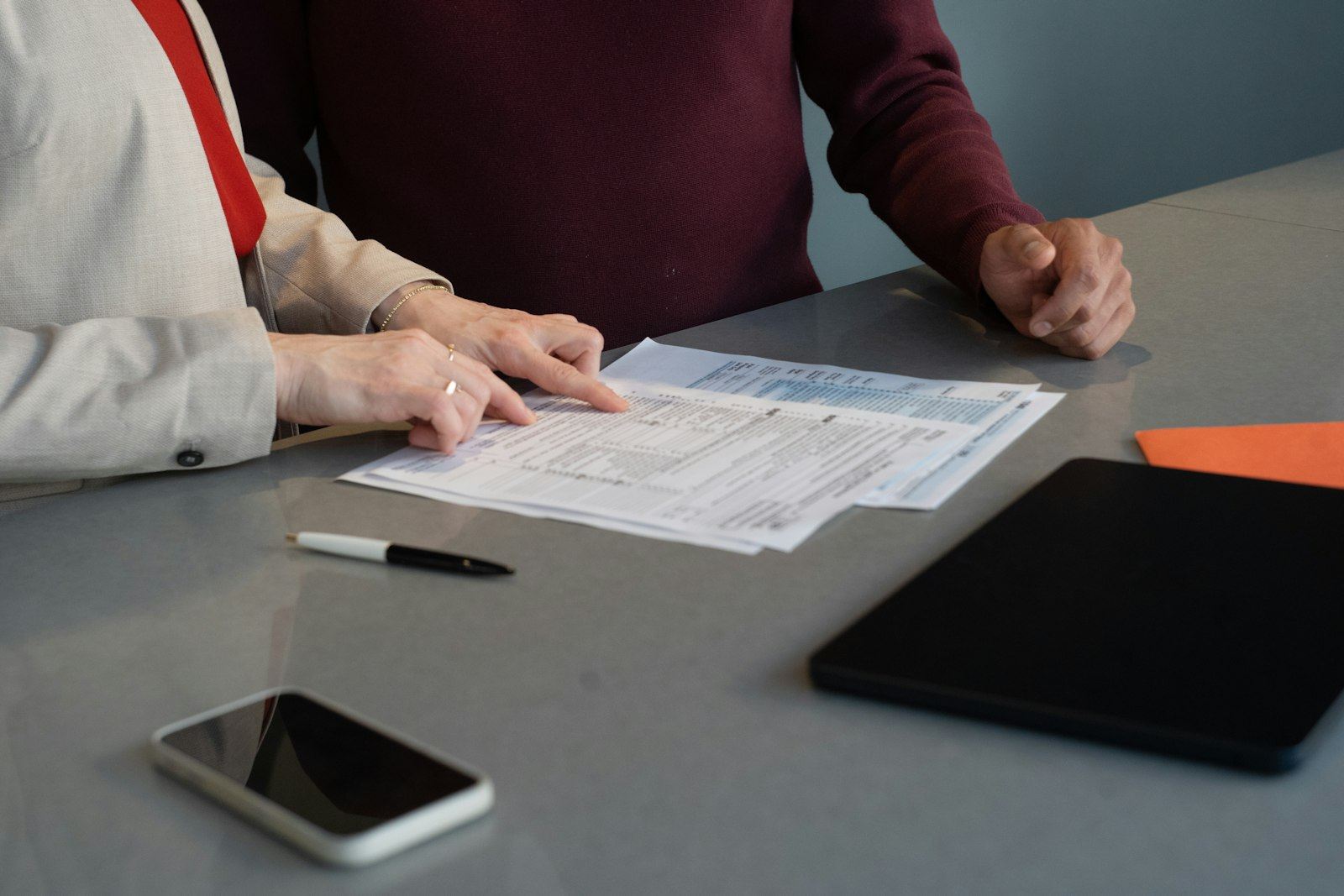 Two people at a table going through a printed plan together.